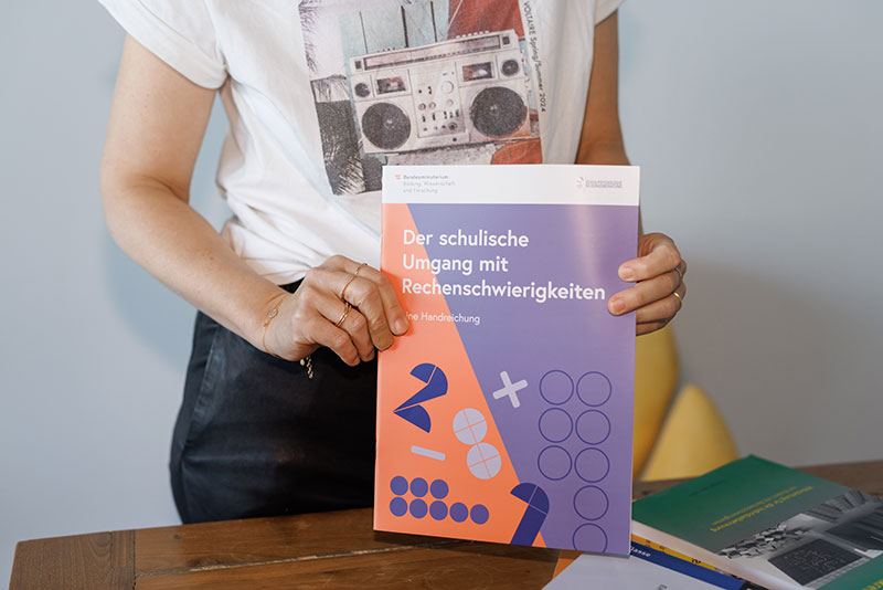 Ein Buch mit dem Titel "Der schulische Umgang mit Rechenschwierigkeiten" wird in die Kamera gehalten