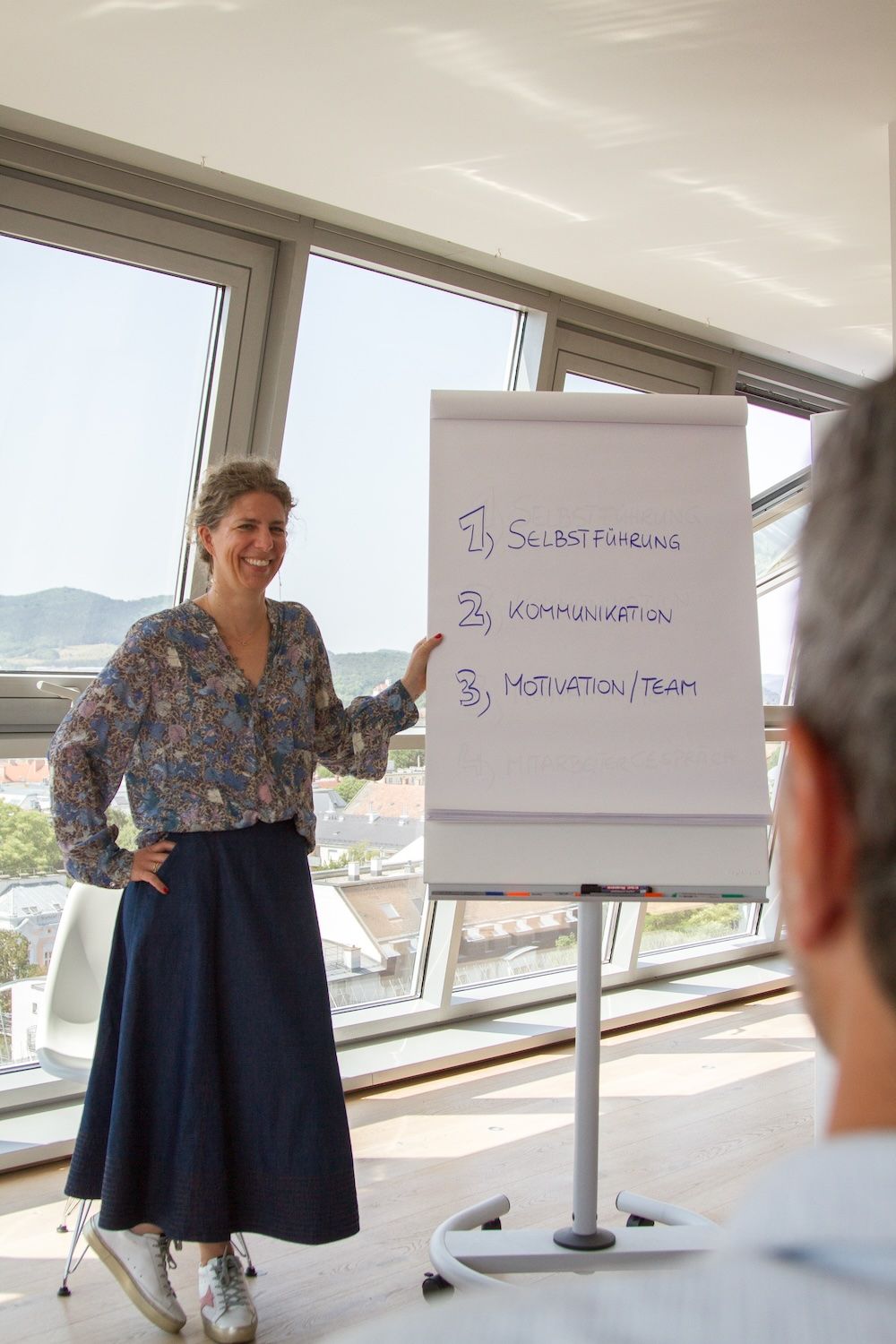 Agnes Goldmann präsentiert ein Flipchart mit dem Text 1.) Selbstfindung 2.) Kommunikation 3.) Motivation/Team
